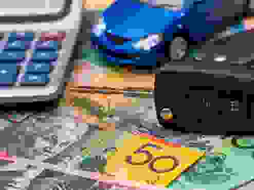 money, car keys and a calculator on a table